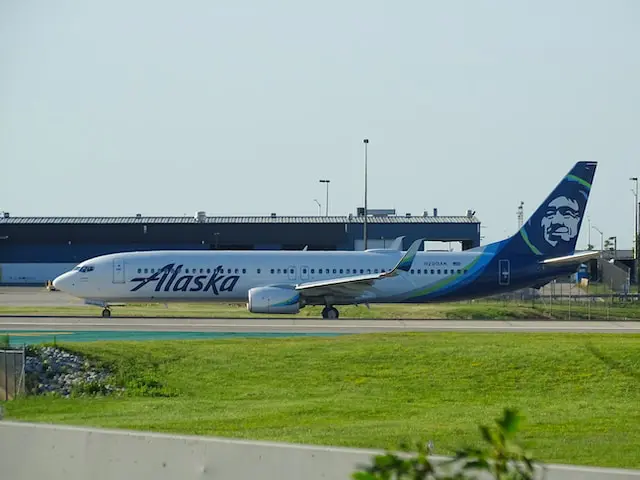 An Alaska Airlines aircraft in mid-air. Learn how to get free flights on Alaska Airlines!