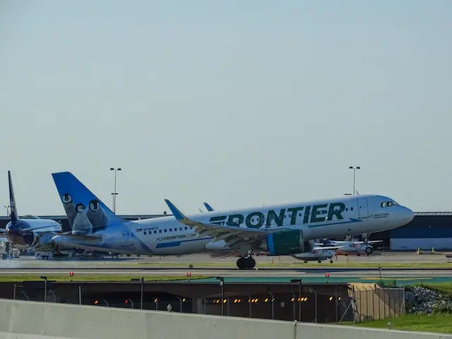 A Frontier Airlines aircraft parked on a landing strip.
