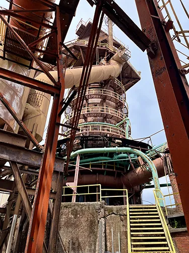 A colored staircase, pipes, and machinery at Sloss Furnaces National Historic Landmark.