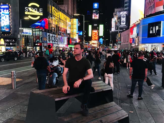 Connecticut vs New York. A picture of the author in Times Square in Manhattan, New York at night.