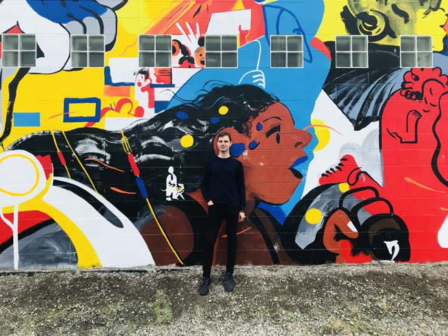 Standing in front of a mural in the southeast quadrant of Portland, OR