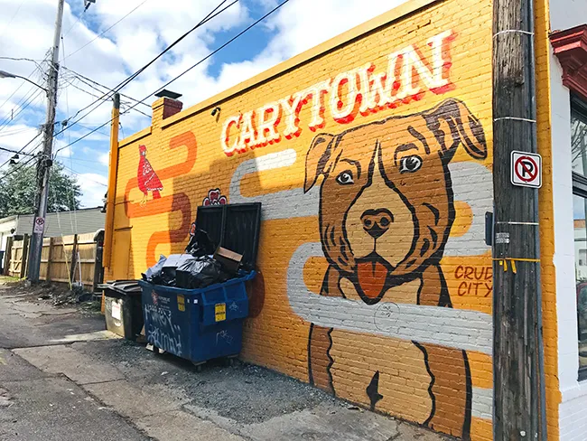 A mural of a dog with the name 'CARYTOWN' on the side of a building in the Carytown district in Richmond, Virginia.